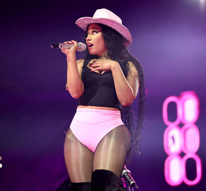 Nicki Minaj performing on stage in a pink hat, amidst concern following her unusual walk at a Trump rally. Nicki Minaj performing on stage in a pink hat, amidst concern following her unusual walk at a Trump rally.