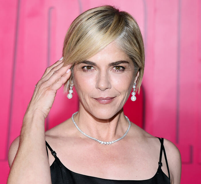 Close-up portrait of Selma Blair posing in front of a pink backdrop. Close-up portrait of Selma Blair posing in front of a pink backdrop.