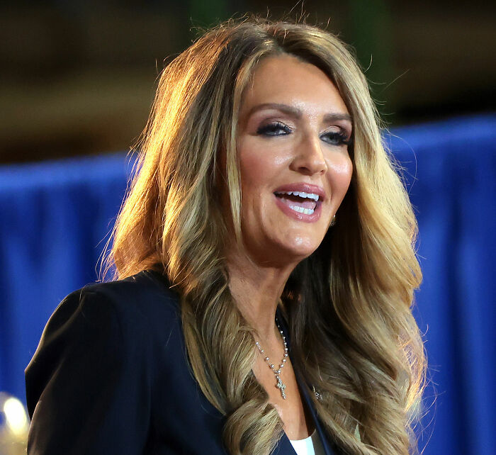 Woman with long blonde hair smiling at an event, related to viral transformation and women in Trump's circle Woman with long blonde hair smiling at an event, related to viral transformation and women in Trump's circle