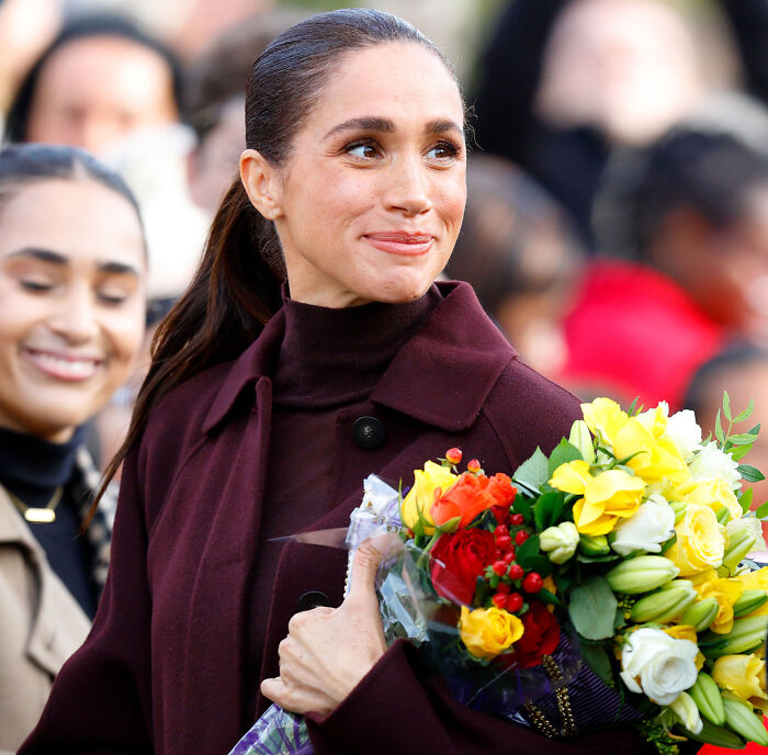 Meghan Markle holding flowers, addressing allegations regarding her father. Meghan Markle holding flowers, addressing allegations regarding her father.