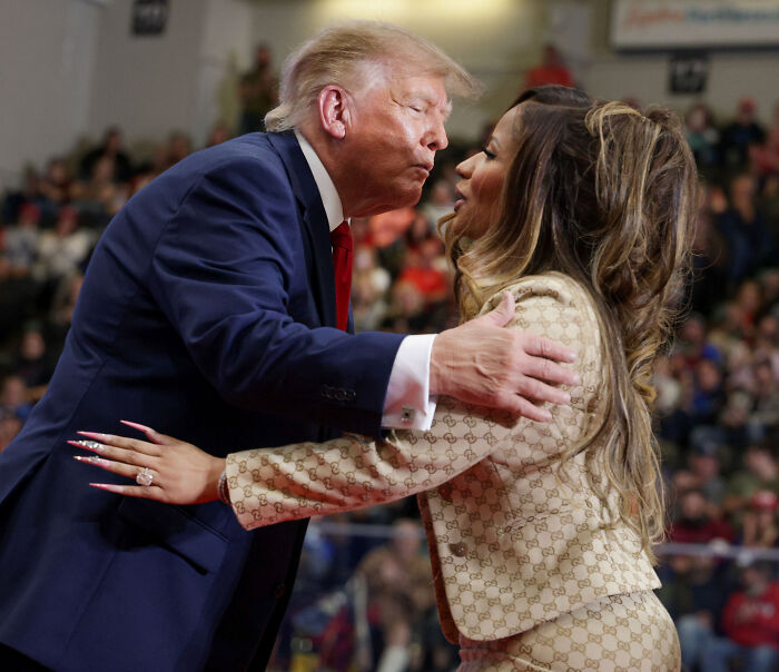 Donald Trump leaning in to greet Nicki Minaj on stage during a political rally. Donald Trump leaning in to greet Nicki Minaj on stage during a political rally.