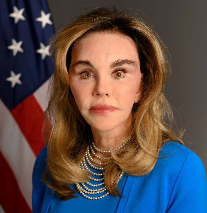 58-year-old MAGA influencer posing in blue suit with American flag background