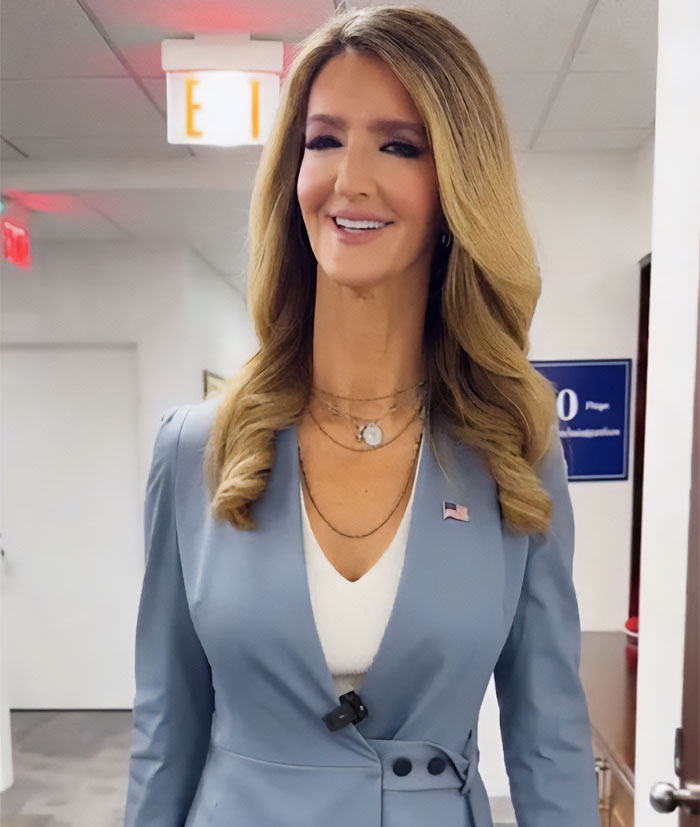 Woman with blonde hair in blue blazer smiling indoors, linked to viral transformation and Trump women Woman with blonde hair in blue blazer smiling indoors, linked to viral transformation and Trump women