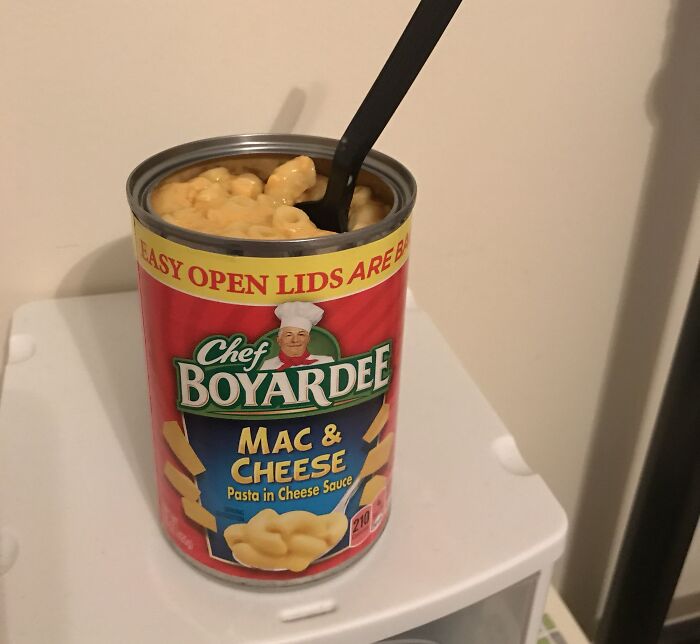 An open can of macaroni and cheese with a fork, tied to petty family feuds over food and household items.