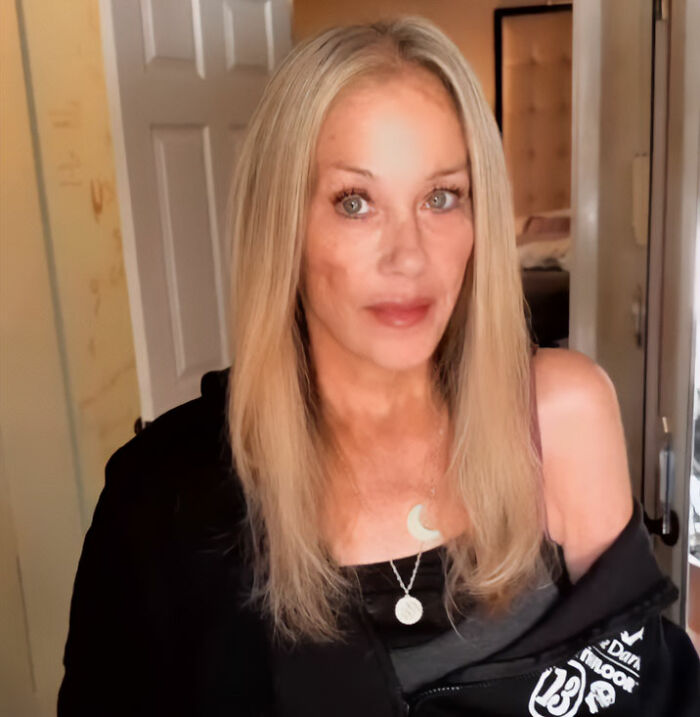 Christina Applegate with blonde hair looking directly into the camera indoors.