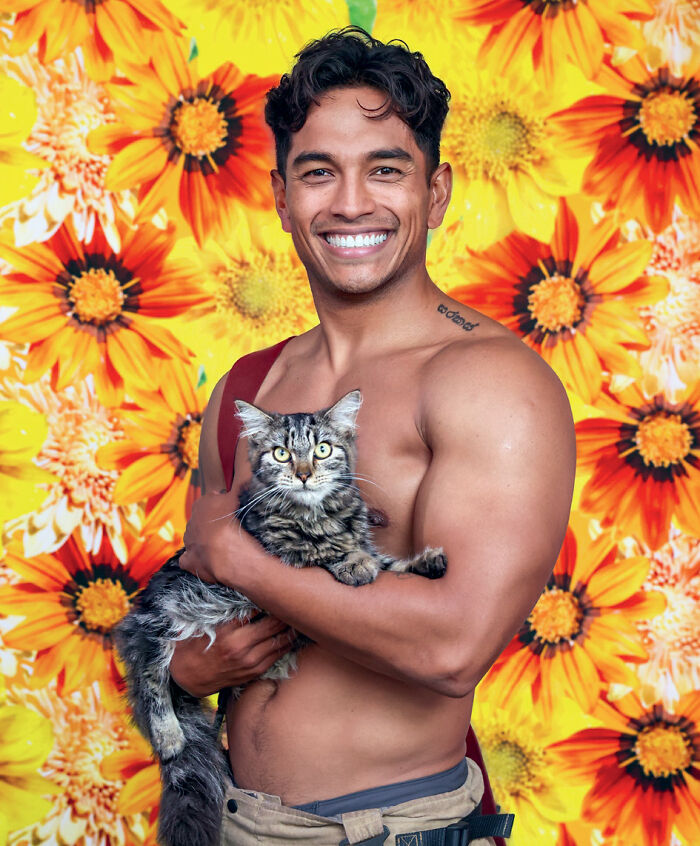 Australian firefighters calendar model holding a tabby cat with sunflowers background