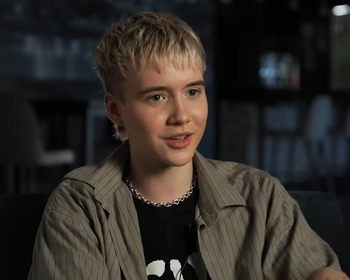 Trans actor with blonde hair speaking during an interview, representing trans actors in Hollywood