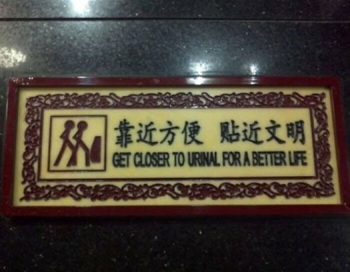 Restroom sign example of translation fails reading get closer to urinal for a better life