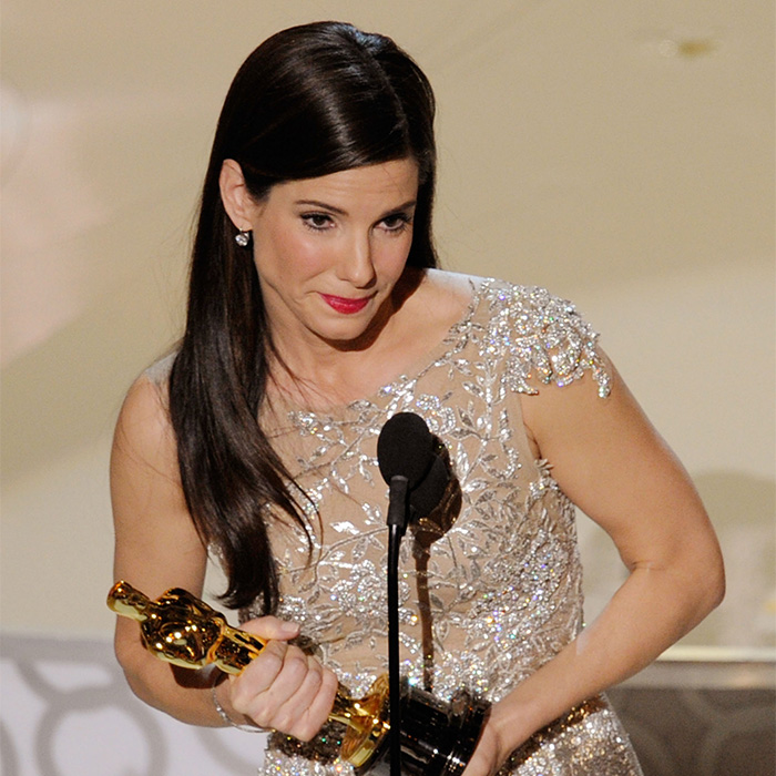 Hollywood actress Sandra Bullock holding her Oscar trophy on stage