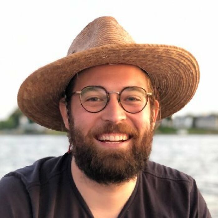 Man wearing glasses and a straw hat smiling outdoors Man wearing glasses and a straw hat smiling outdoors
