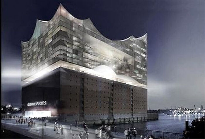 Modern architectural building with illuminated wavy glass exterior at night