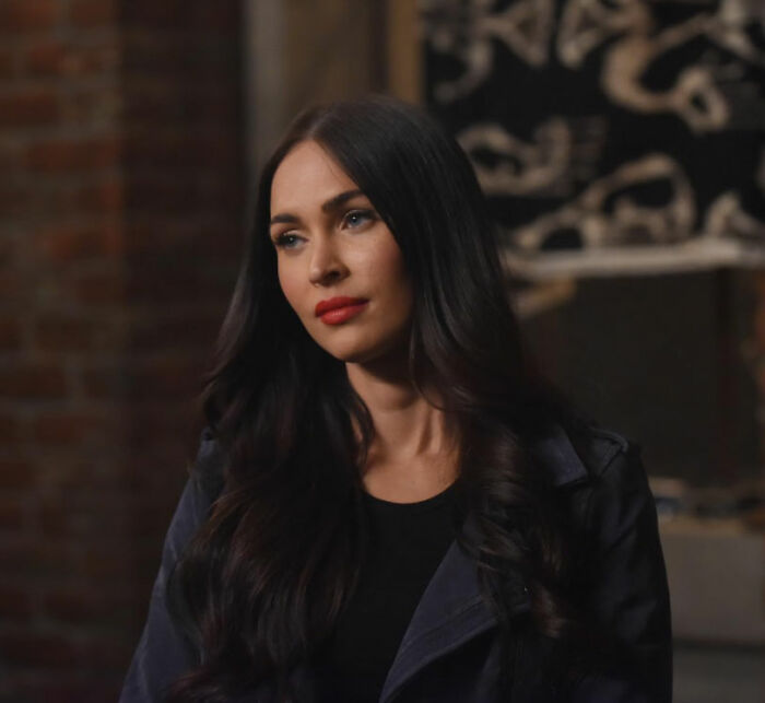 Megan Fox with dark hair and red lipstick, representing famous stars and their career journeys.