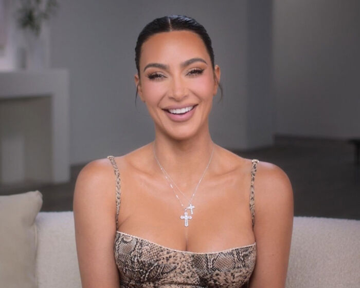 Kim Kardashian smiling in a snake-print dress, representing famous figures involved in huge PR stunts.