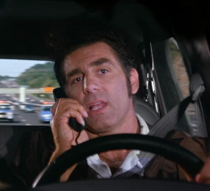 Michael Richards on the phone in a car, representing stars who got in the way of their own success.