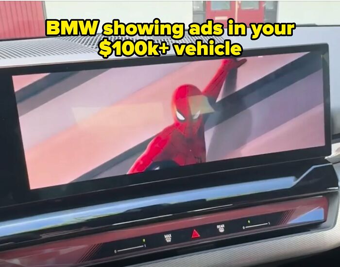 BMW display screen showing ads, highlighting absurdities of modern life in America.