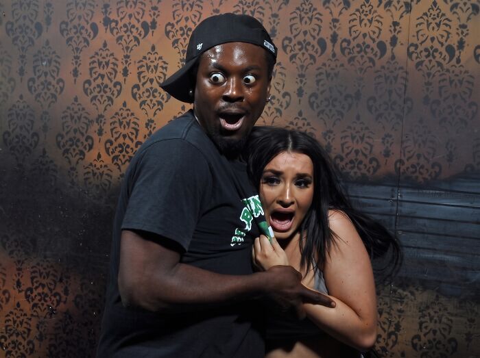 A scared man and woman reacting in a funny haunted house photo.