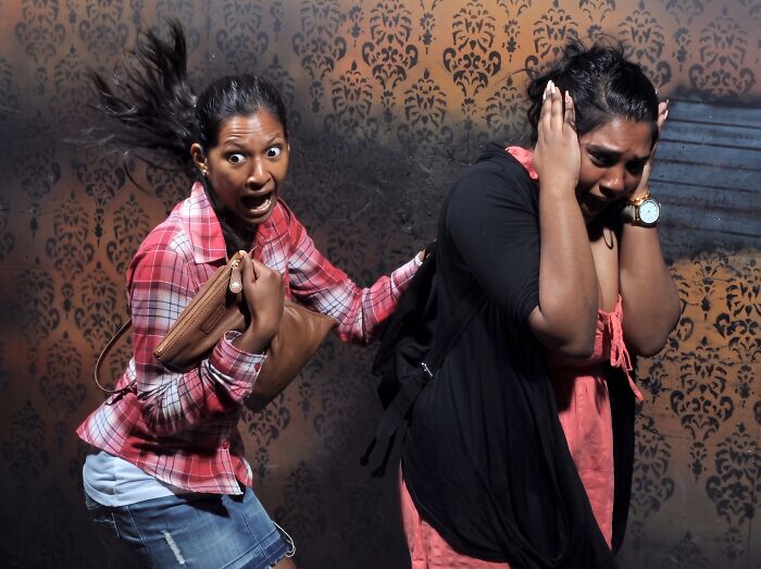 Scared women reacting in a haunted house photo with wide eyes