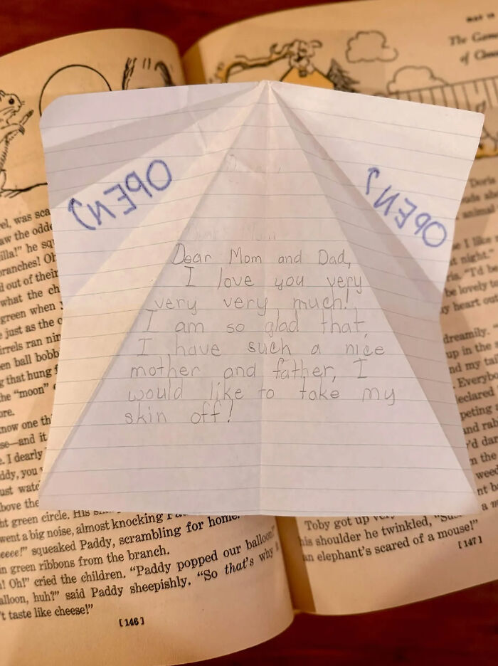 Found paper note with handwritten message to parents lying on top of an open book.