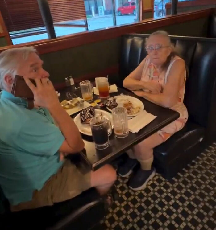 A Karen couple calling police on restaurant manager while sitting at a restaurant booth with food. A Karen couple calling police on restaurant manager while sitting at a restaurant booth with food.