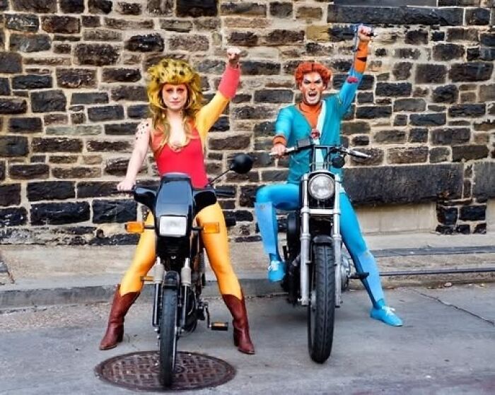 Man and woman posing on motorbikes in bright funny cool halloween couples costumes