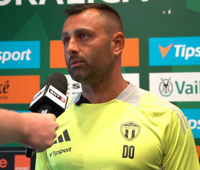 Coach avoiding eye contact during awkward interview in sportswear