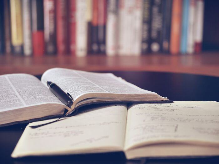Open textbook with notes and pen, representing academic research related to boycotted companies
