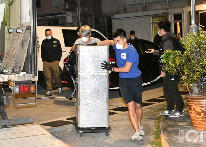 Men moving large wrapped refrigerator at night with masks and gloves Men moving large wrapped refrigerator at night with masks and gloves