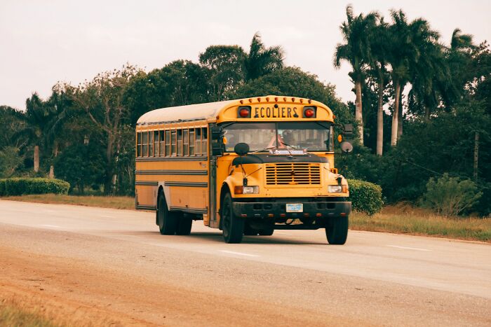 Yellow school bus on the road carrying people who found secrets