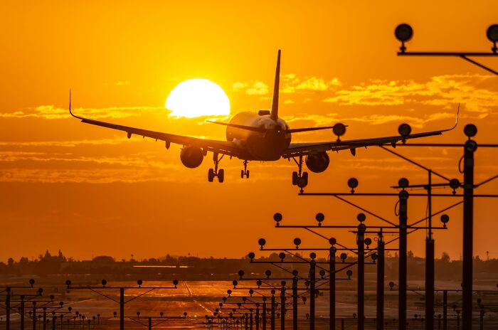 An airplane landing at sunset, symbolizing long-distance secrets and journeys