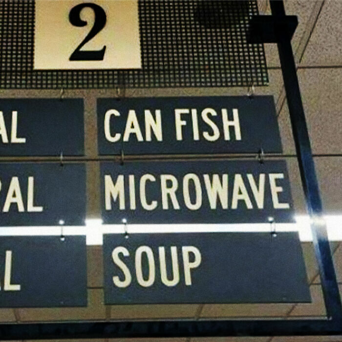 Grocery store aisle sign displaying confusing text like CAN FISH MICROWAVE SOUP in advertising fails.