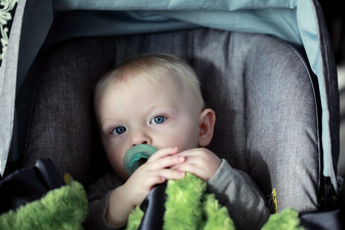 A close-up of a baby sitting in a stroller during family flights