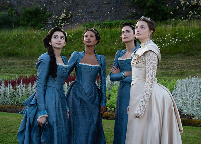 Four women dressed in historical attire on set, highlighting a popular Hollywood Actress.