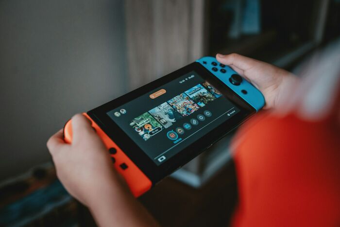 A kid holding a portable gaming console to play during flights