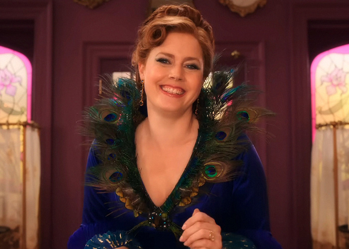 Hollywood star Amy Adams smiling in a vibrant costume with a peacock feather collar