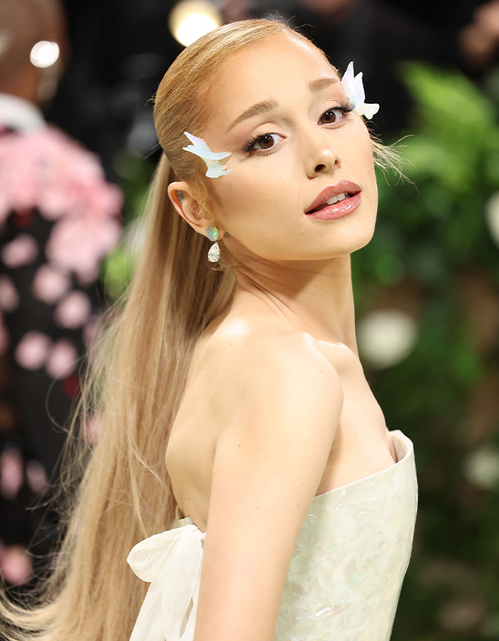 Ariana Grande with blonde hair pulled back in a sleek look for a dramatic hair transformation.