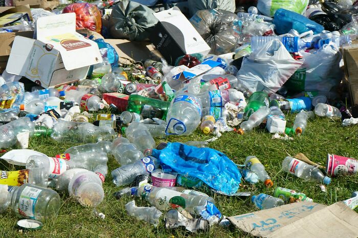 Trash and plastic bottles scattered outside on grass