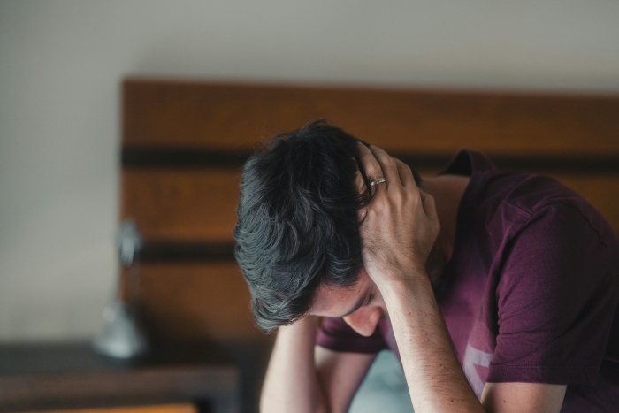 A stressed man with his head in his hands, showcasing the emotional toll of couple fights. A stressed man with his head in his hands, showcasing the emotional toll of couple fights.