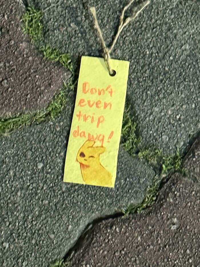 Yellow bookmark with a pikachu drawing lying on stone ground as found paper