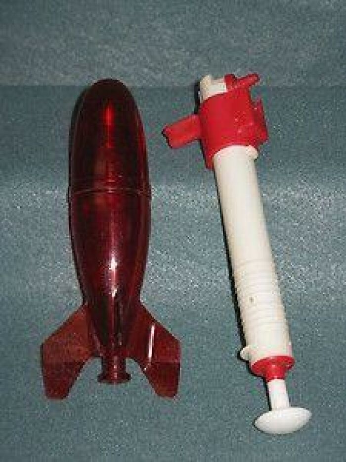 A red vintage plastic rocket toy with a white launch pump, classic nostalgic photos from 80s kids childhoods.
