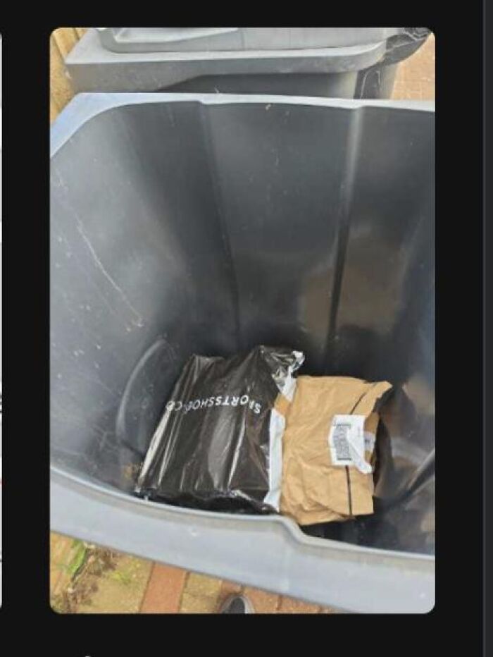 A mail package delivered right inside a trash bin outside, creating an absurd moment.