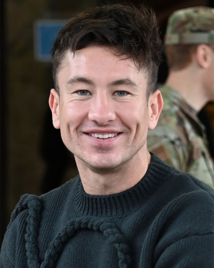Barry Keoghan smiling in a dark sweater, facing backlash over his appearance and cosmetic procedure.