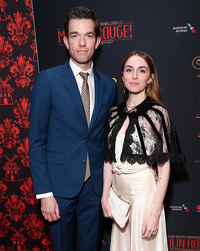 Man and woman posing on red carpet at event