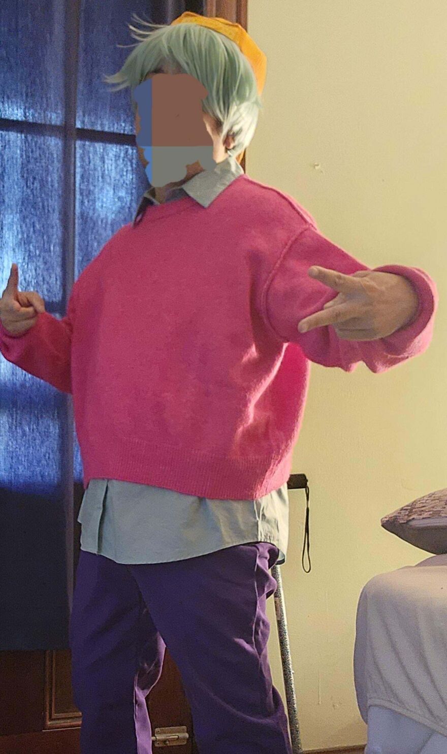 Person dressed in a colorful sweater and wig posing in a unique Halloween costume.