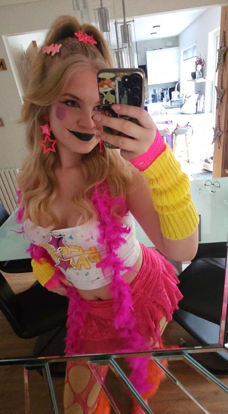 Woman wearing a colorful 80s pop star Halloween costume taking a selfie.