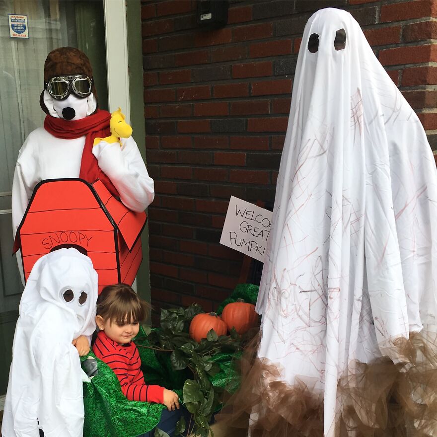 Family dressed as Peanuts characters and sheet ghost Halloween costumes