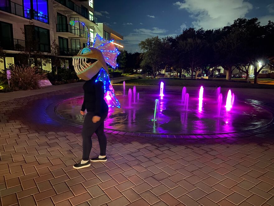 A person wearing a glowing anglerfish mask outdoors highlighting creative Halloween costumes at night