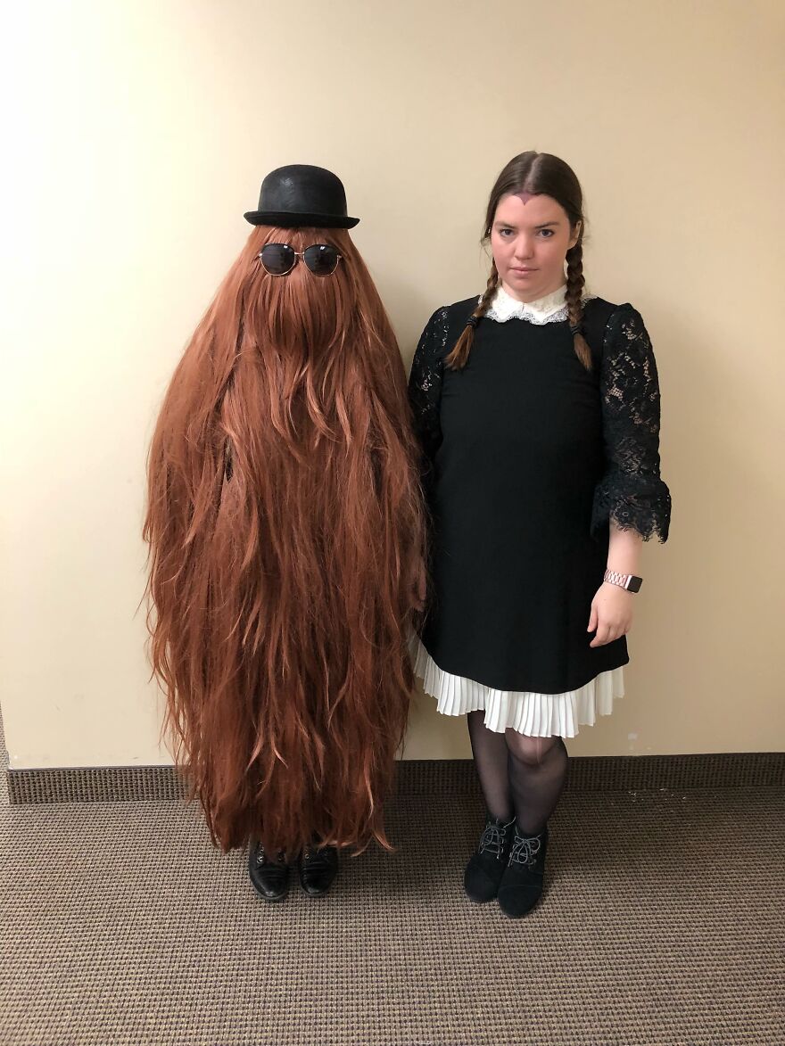 Two people dressed up as Cousin Itt and Wednesday Addams demonstrating impressive Halloween costumes