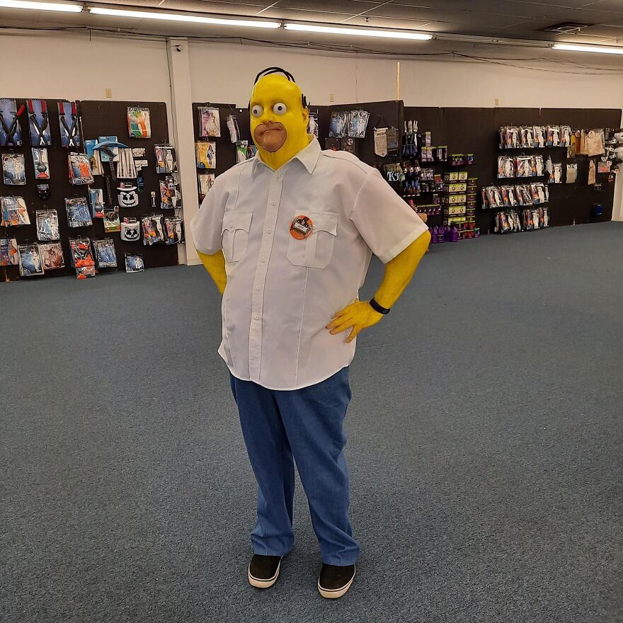 A person dressed as Homer Simpson in a white shirt and blue pants showcasing creative Halloween costumes