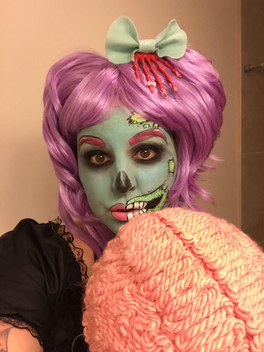 Woman with blue face paint and purple wig, showcasing spooky Halloween costumes