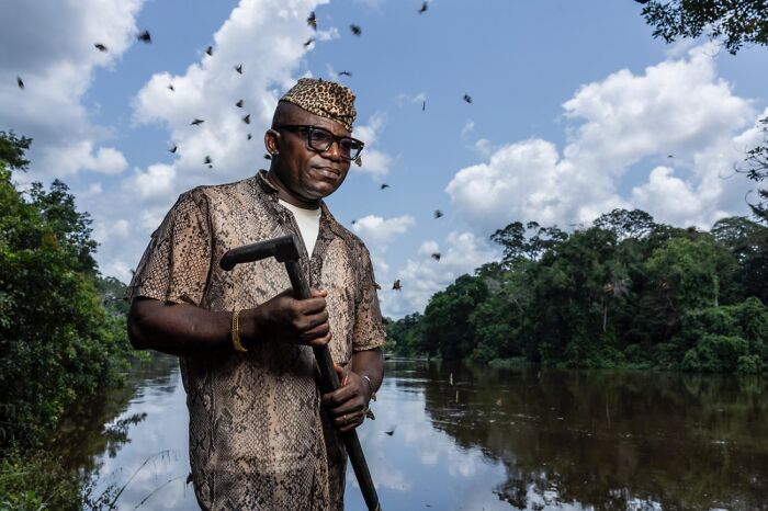 Man by river surrounded by flying bees in Siena International Photo Awards image